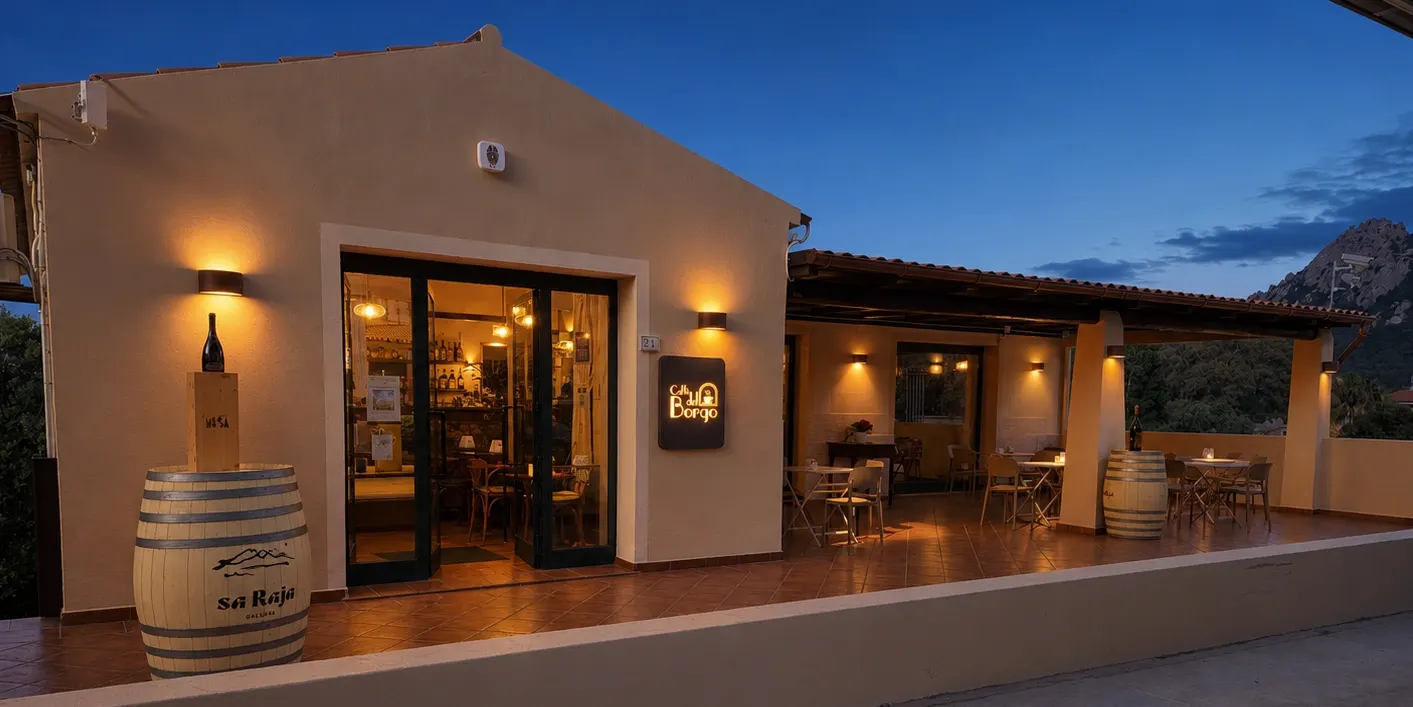 Ingresso e veranda illuminata di Caffè del Borgo al tramonto, con tavolini esterni e insegna luminosa